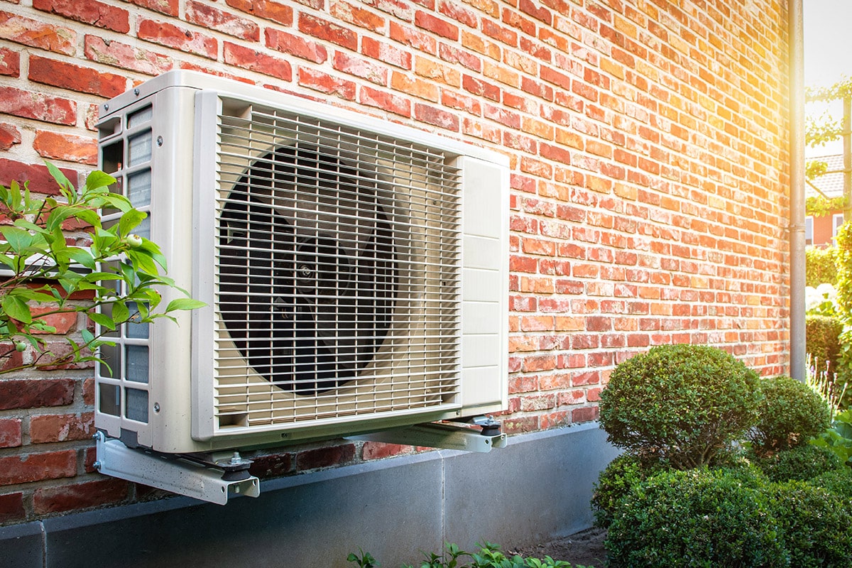 Air conditioning heat pump outdoor unit against brick wall. Luft-Luft-Wärmepumpe- Alternative Heizungen für den Altbau